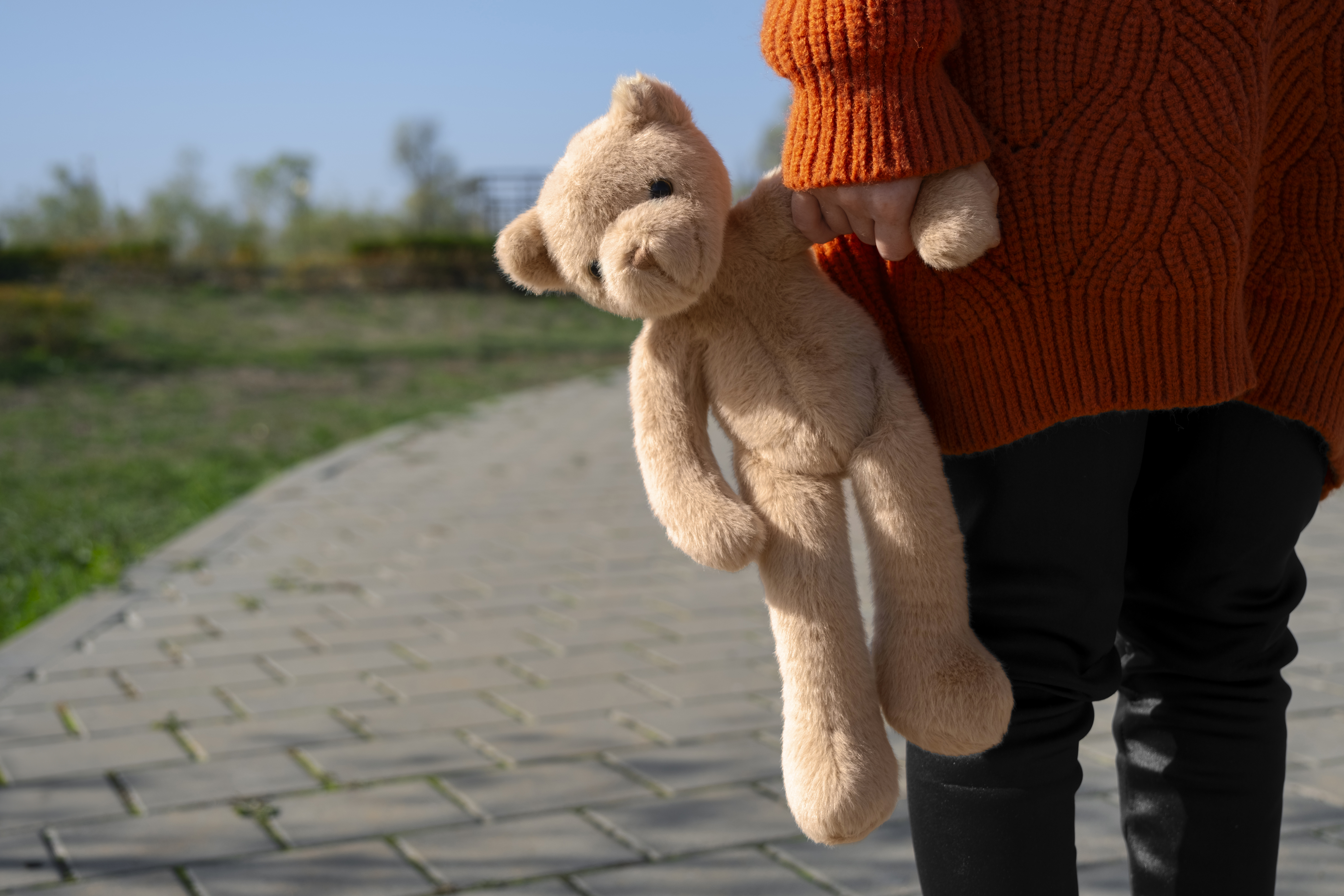 front-view-kid-holding-teddy-bear-outdoors.jpg